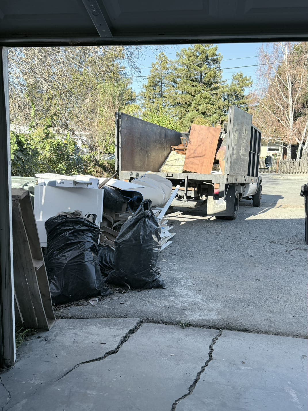 Loaded junk removal truck hauling bulky debris from a commercial cleanout site